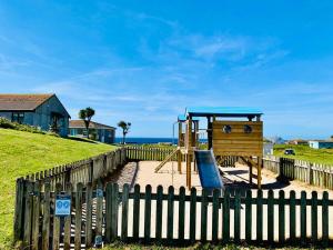 a playground in front of a wooden fence at Pensilva in Hayle