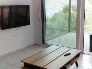 a living room with a wooden table and a large window at Sun & Sea Apartments Plakias II in Plakias