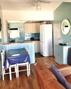 a kitchen with a table and a white refrigerator at Pensilva in Hayle