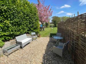 a backyard with chairs and a table and a fence at Beautiful cottage in country village near Longleat in Maiden Bradley