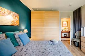 モンドルフ・レ・バンにあるHomestay in a nice flatの緑の壁のベッドルーム1室、青い枕付きのベッド1台が備わります。