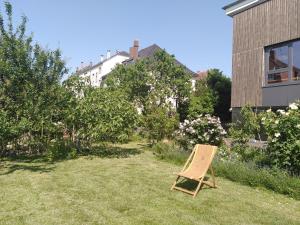 a chair sitting in a yard next to a building at La chambre de la maison bleue in Colmar