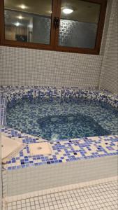 a large tub with blue and white tiles in a bathroom at Apartmani Vila Bjelasica in Kolašin