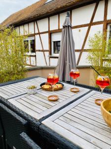 a wooden table with three wine glasses on it at Un petit écrin au cœur du vignoble alsacien in Mittelwihr