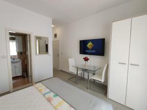 1 dormitorio con cama, mesa y TV en Montesun Residence en Herceg-Novi