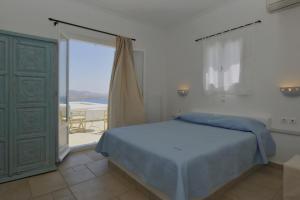 a bedroom with a bed and a large window at Degaetas Resort in Antiparos