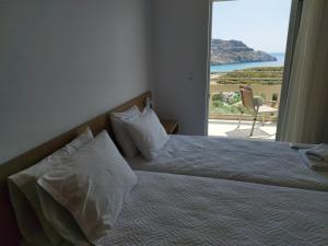 a bedroom with a bed with a view of the ocean at Sun & Sea Apartments Plakias II in Plakias