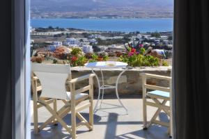 a table and chairs on a balcony with a view at Degaetas Resort in Antiparos