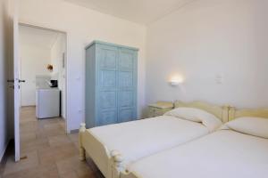 a bedroom with two beds and a blue cabinet at Degaetas Resort in Antiparos