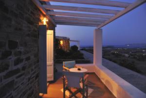 a table and two chairs on a balcony at night at Degaetas Resort in Antiparos