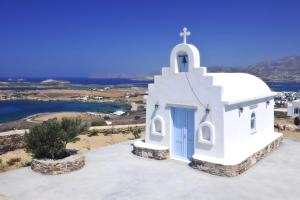 a white church with a blue door on top of it at Degaetas Resort in Antiparos