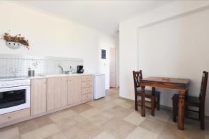 a kitchen with a table and a sink and a stove at Degaetas Resort in Antiparos