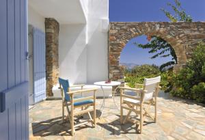 a patio with a table and chairs and an archway at Degaetas Resort in Antiparos Town