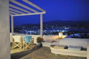 a balcony with a view of the water at night at Degaetas Resort in Antiparos