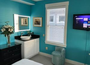 a bathroom with a sink and a tv on the wall at Lotus Provincetown in Provincetown