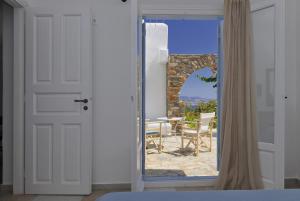 a door leading to a patio with a table and chairs at Degaetas Resort in Antiparos