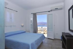 a bedroom with a bed and a view of the ocean at Degaetas Resort in Antiparos