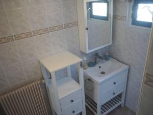 y baño con lavabo blanco y espejo. en Maison sur ferme maraichère bio, en Guiler-sur-Goyen