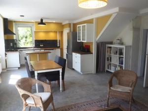 cocina con mesa y sillas en una habitación en Maison sur ferme maraichère bio, en Guiler-sur-Goyen