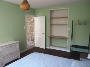 1 dormitorio con paredes verdes y 1 cama con tocador en Maison sur ferme maraichère bio, en Guiler-sur-Goyen