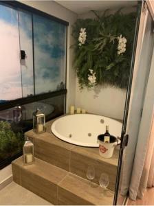 a bathroom with a tub and a large window at Wanderlust Experience Hotel in Campos do Jordão
