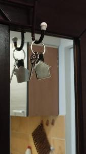 a pair of keys hanging from a bathroom mirror at Downtown Authentic Apartment Tirana Myslym Shyri in Tirana