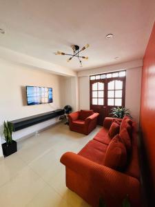 un soggiorno con divano rosso e TV a schermo piatto di Castellares la Puebla Hostelería Departamento ad Ayacucho