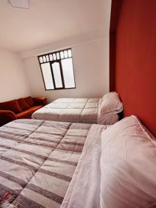 a bedroom with two beds and a window at Castellares la Puebla Hostelería Departamento in Ayacucho