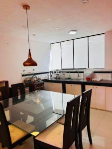 a kitchen with a glass dining table and chairs at Castellares la Puebla Hostelería Departamento in Ayacucho