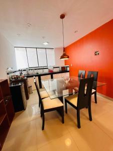 a dining room with a glass table and chairs at Castellares la Puebla Hostelería Departamento in Ayacucho