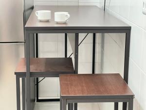 een klein tafeltje met twee kopjes en een bankje bij Curitiba Central - Apartamento completo e perto de tudo in Curitiba +13 foto's