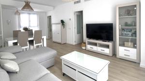 een woonkamer met een bank en een tv bij Apartamento Málaga Beach, 2A in Málaga