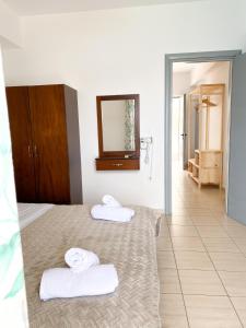 Habitación de hotel con 2 camas y espejo en Acta's Rooms, en Himare