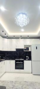 a kitchen with white cabinets and a chandelier at Malinki in Odesa