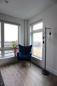 una sedia blu in una stanza con due finestre di 1BR Luxury Apartment Peabody Unit 709 a Peabody