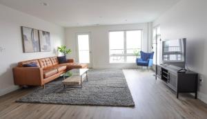 a living room with a brown leather couch and a rug at 1BR Luxury Apartment Peabody Unit 709 in Peabody