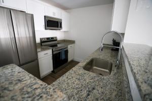 cocina con fregadero y nevera de acero inoxidable en 1BR Luxury Apartment Peabody Unit 709 en Peabody