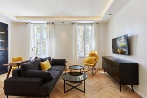 普罗旺斯艾克斯Appartement exceptionnel avec parking Centre-ville Aix-en-Provence的客厅里有一张沙发和一张桌子。