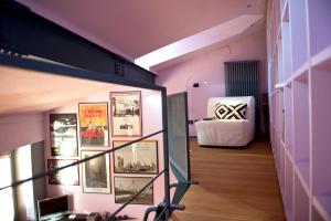 a hallway with a bed and pictures on the wall at Casa Rossa - byMyHomeinComo in Cernobbio