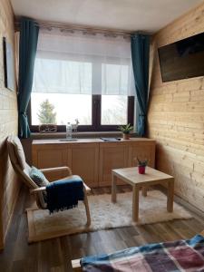 a living room with a table and a window at WeiXL Schi&Bike Appartements-Bike in&Bike out neben Wexl Trails Bikepark in Sankt Corona am Wechsel