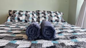 een bed met een paar slippers en handdoeken erop bij Curitiba Central - Apartamento completo e perto de tudo in Curitiba