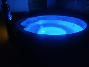 a blue bath tub in a dark room at Gîte avec son bain nordique privatif au feu de bois in Pleubian