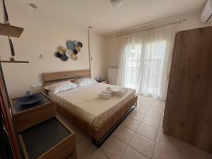Un dormitorio con una cama grande y una ventana en To Spiti, en Keramotí