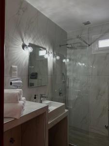 y baño con ducha acristalada y lavamanos. en To Spiti, en Keramotí