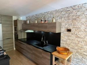 cocina con fregadero y pared de ladrillo en appartement T4 type chalet pra-loup en Uvernet-Fours