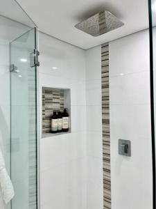 baño con ducha y puerta de cristal en Bondi Beach Waves Beachfront Apartment en Sídney