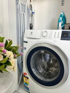 a white washing machine in a room with flowers at Bondi Beach Waves Beachfront Apartment in Sydney