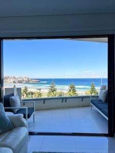 uma sala de estar com uma grande vista para o oceano em Bondi Beach Waves Beachfront Apartment em Sydney
