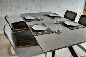 una mesa con sillas, platos y vasos. en Chalet Alba, en Lichtenberg