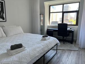 um quarto com uma cama, uma secretária e uma janela em Cozy oasis double king size bed: Bell Center - Heart of downtown em Montreal
